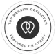 Circular badge with a black and white design. It features a stylized heart icon in the center and is surrounded by the text: "Top Website Developer Featured on UpCity. - Clio Websites | Top Canadian Web Design Company